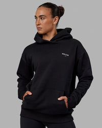 Woman wearing Unisex RUN-CLUB Hoodie Oversize - Black