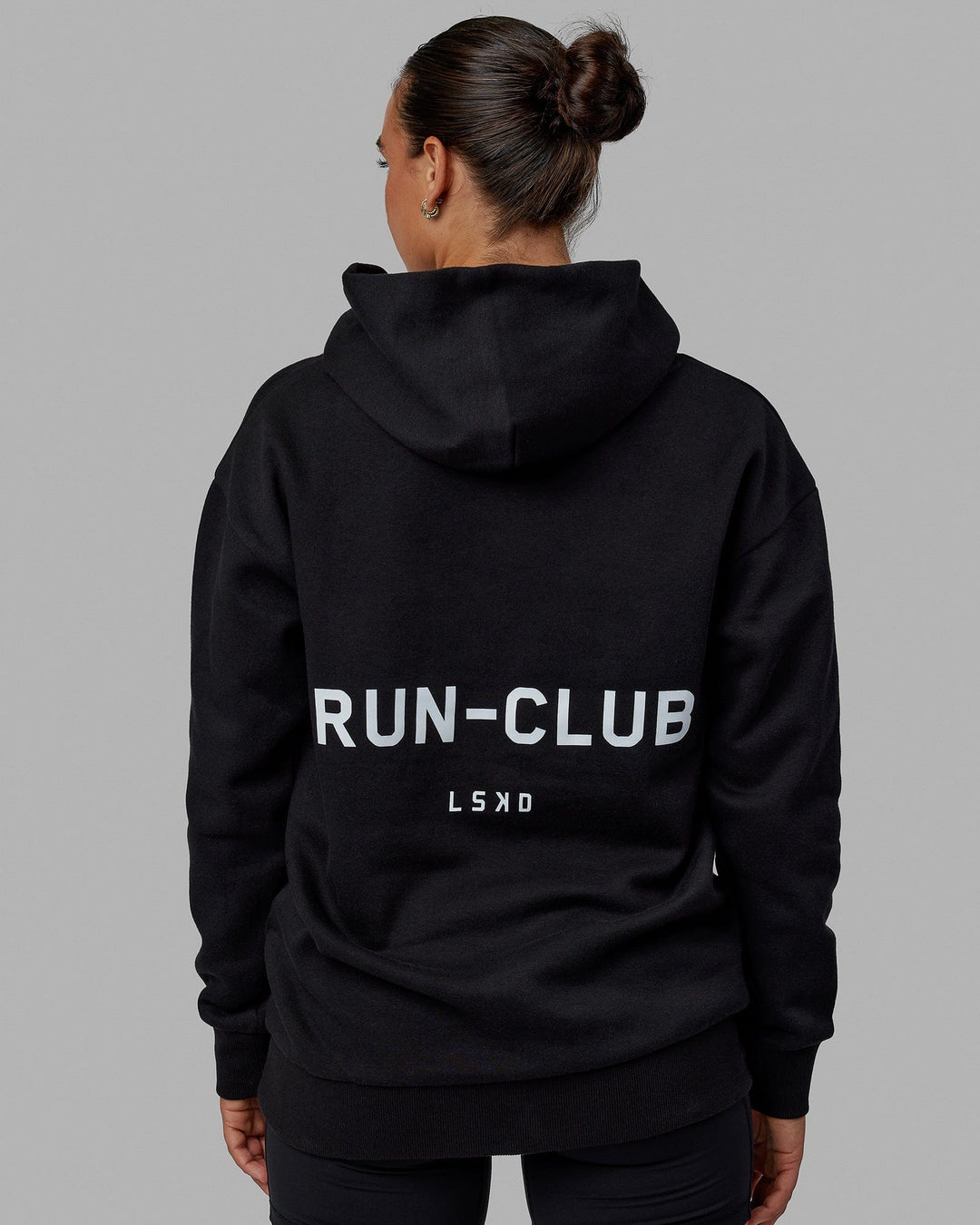 Woman wearing Unisex RUN-CLUB Hoodie Oversize - Black