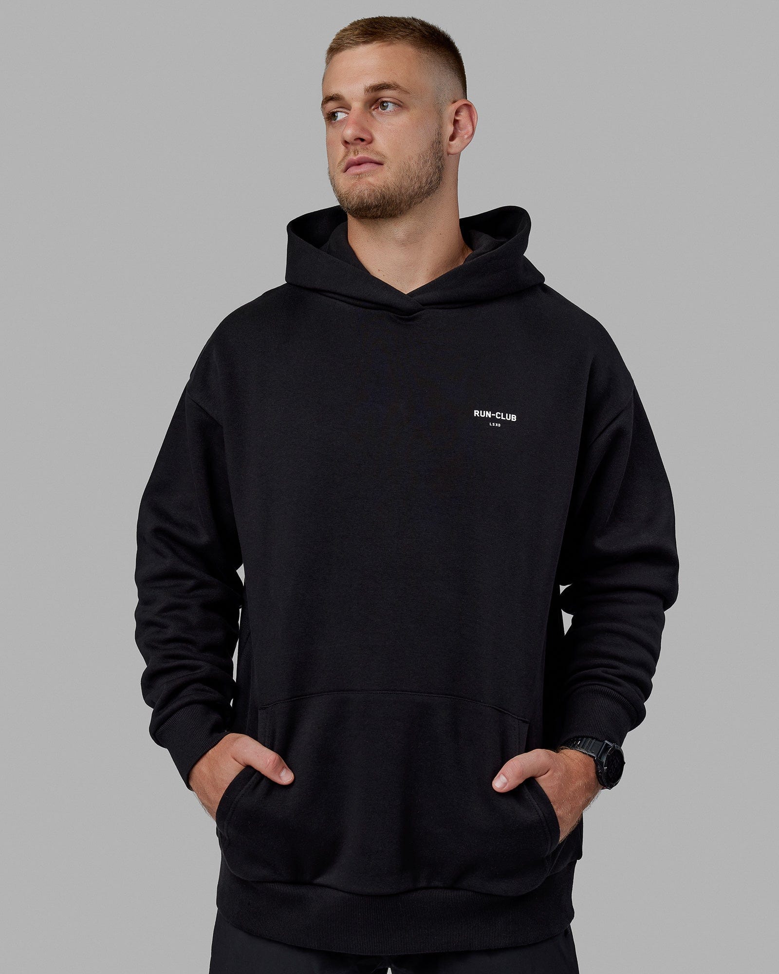 Man wearing Unisex RUN-CLUB Hoodie Oversize - Black
