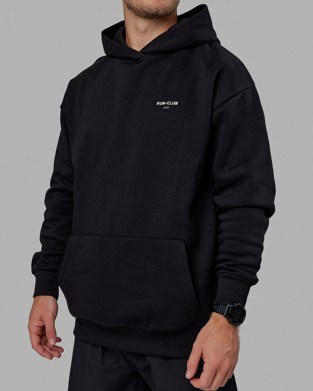 Man wearing Unisex RUN-CLUB Hoodie Oversize - Black