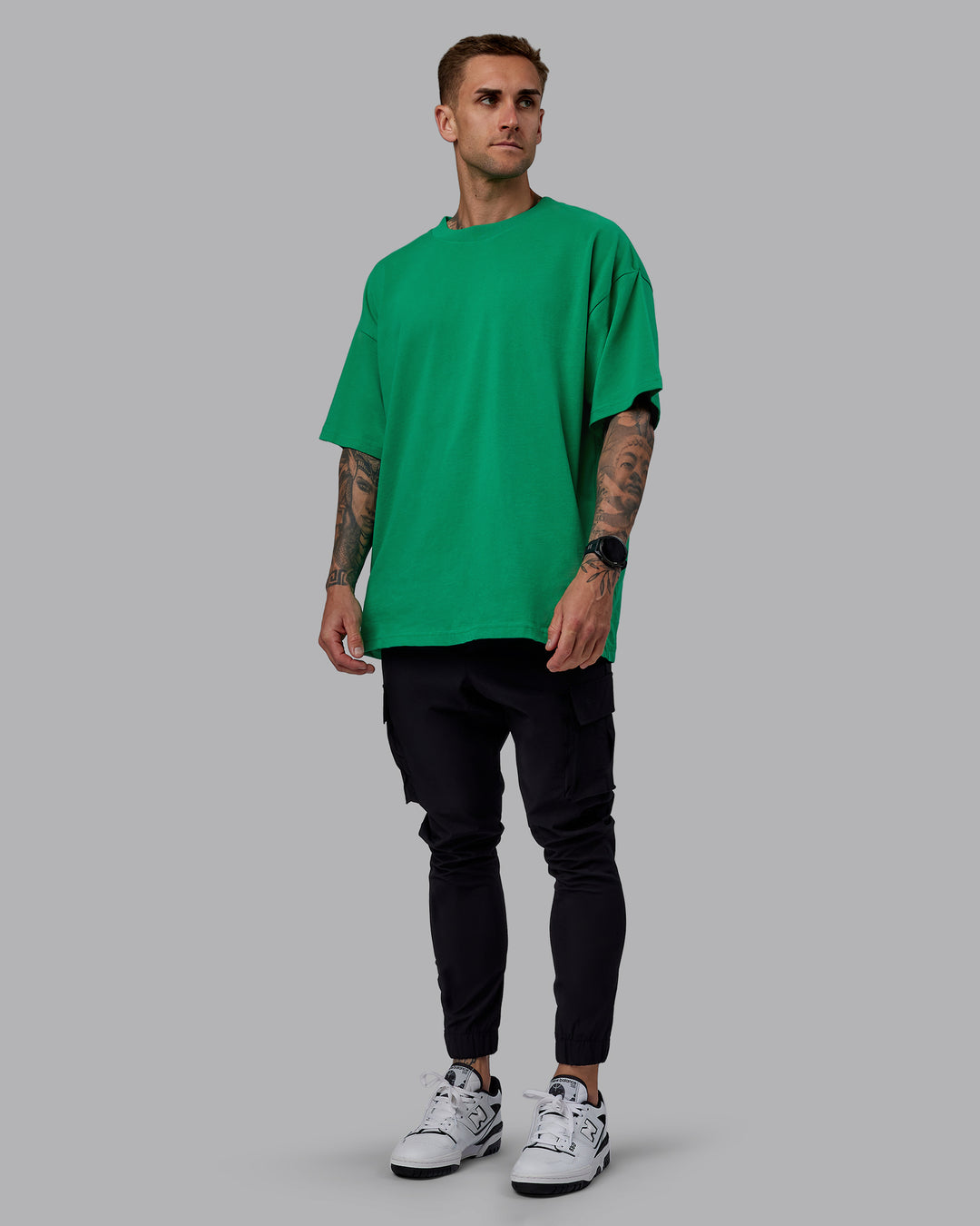 Man wearing Unisex We Rise Heavyweight Tee Oversize - Impact Green-White