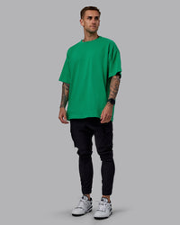 Man wearing Unisex We Rise Heavyweight Tee Oversize - Impact Green-White