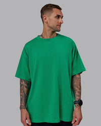 Man wearing Unisex We Rise Heavyweight Tee Oversize - Impact Green-White