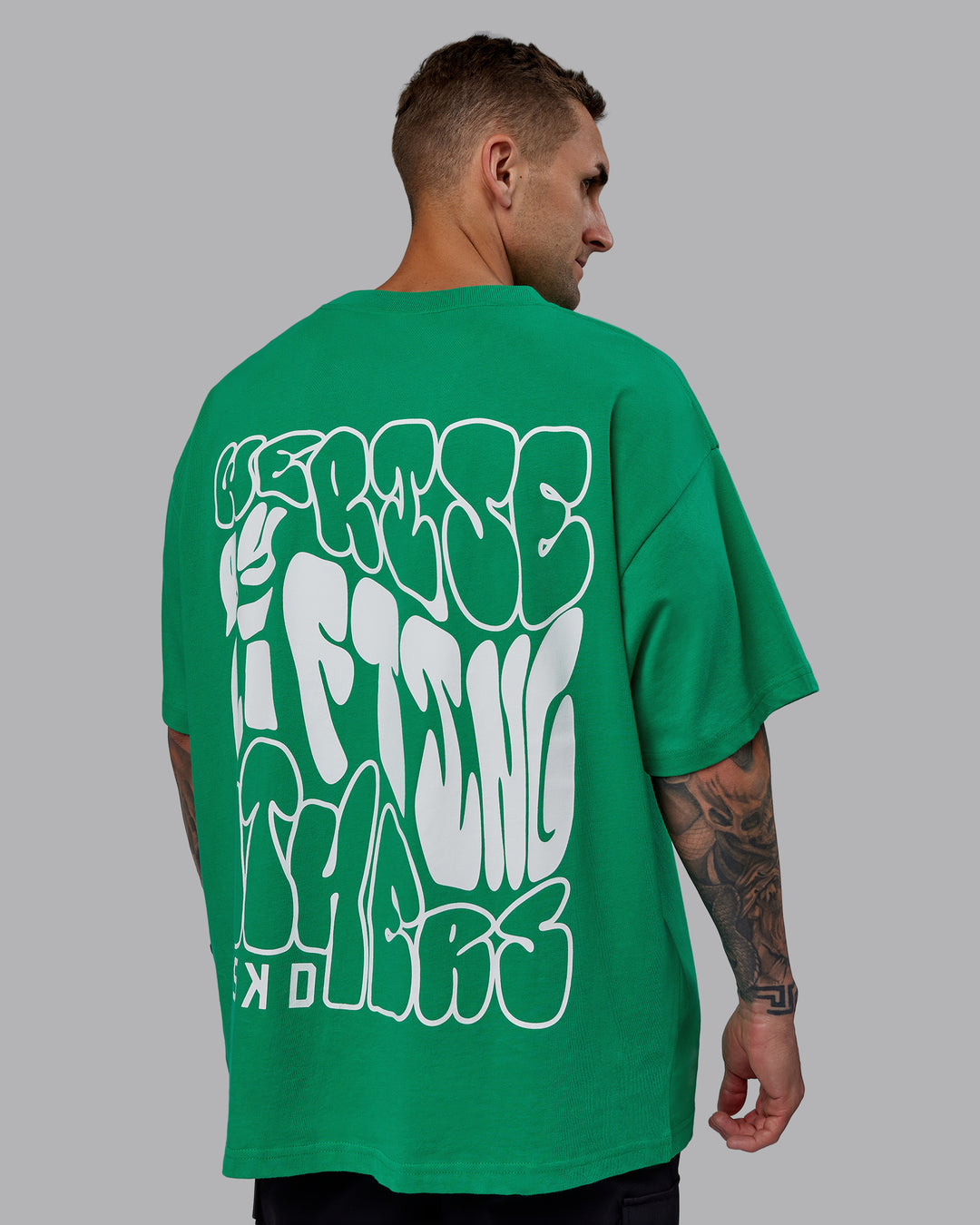Man wearing Unisex We Rise Heavyweight Tee Oversize - Impact Green-White