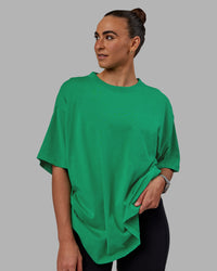 Woman wearing Unisex We Rise Heavyweight Tee Oversize - Impact Green-White