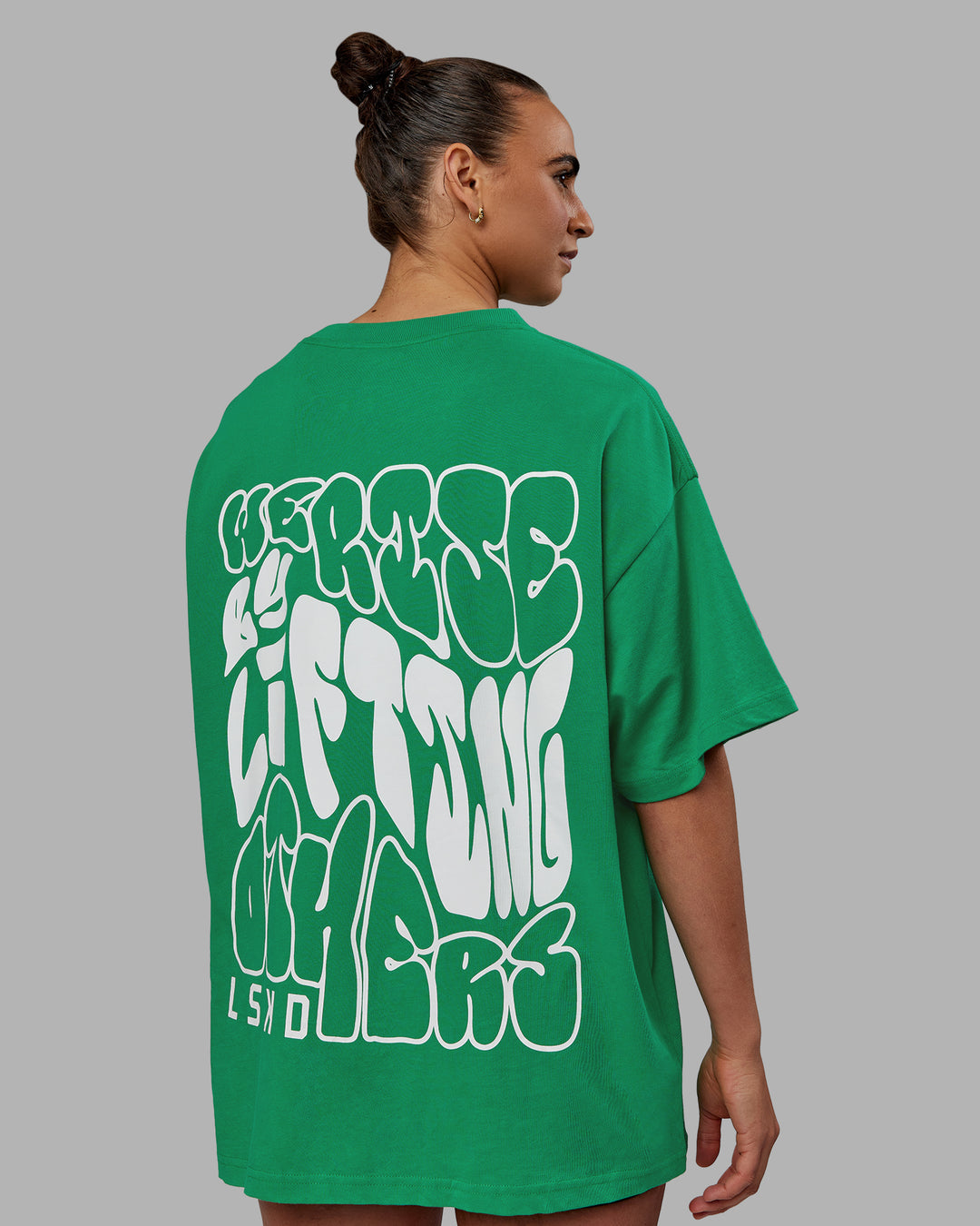 Woman wearing Unisex We Rise Heavyweight Tee Oversize - Impact Green-White