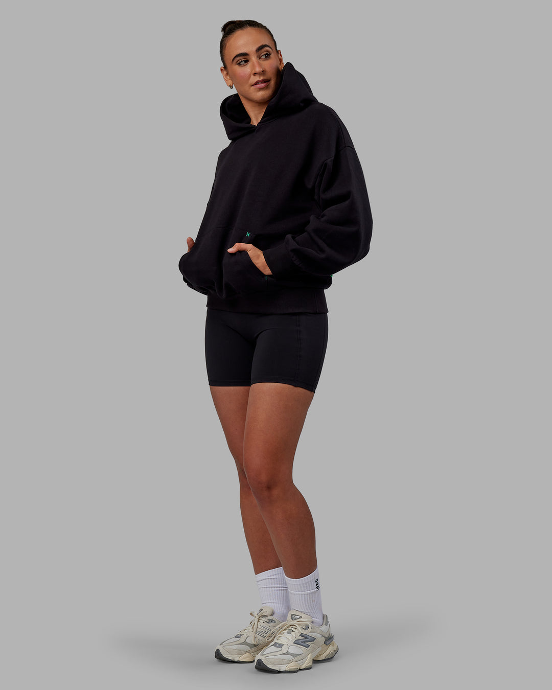 Woman wearing Unisex We Rise Hoodie Oversize - Black-Impact Green