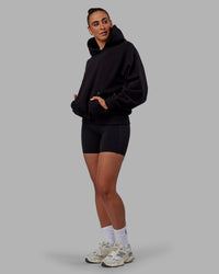 Woman wearing Unisex We Rise Hoodie Oversize - Black-Impact Green