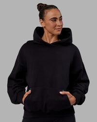 Woman wearing Unisex We Rise Hoodie Oversize - Black-Impact Green