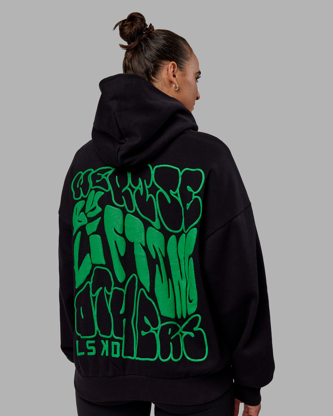 Woman wearing Unisex We Rise Hoodie Oversize - Black-Impact Green