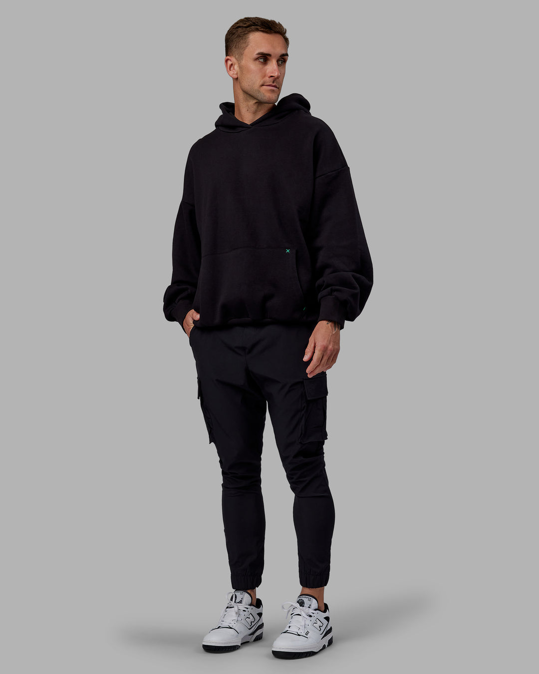 Man wearing Unisex We Rise Hoodie Oversize - Black-Impact Green