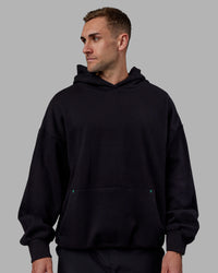 Man wearing Unisex We Rise Hoodie Oversize - Black-Impact Green