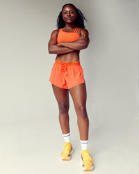 Woman wearing Accelerate 3" Run Short - Ultra Orange | Model:Cebile | Size:S