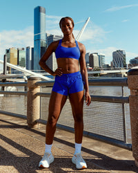 Woman wearing Accelerate 3" Mid-Rise Running Short - Electric Indigo | Model:Naa | Size:S