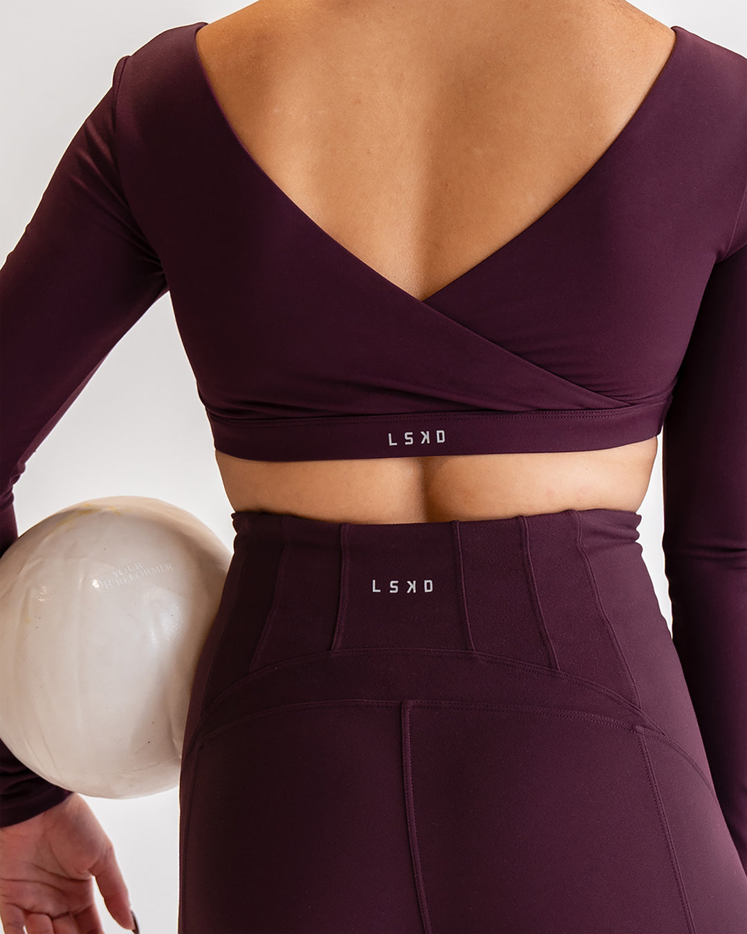Woman wearing Aria Long Sleeve Sports Bra - Cherry Lacquer | Model:Sarah | Size:S