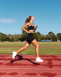 Woman wearing Elite Run High-Rise 5" Short Pockets - Black | Model:Emelia | Size:S