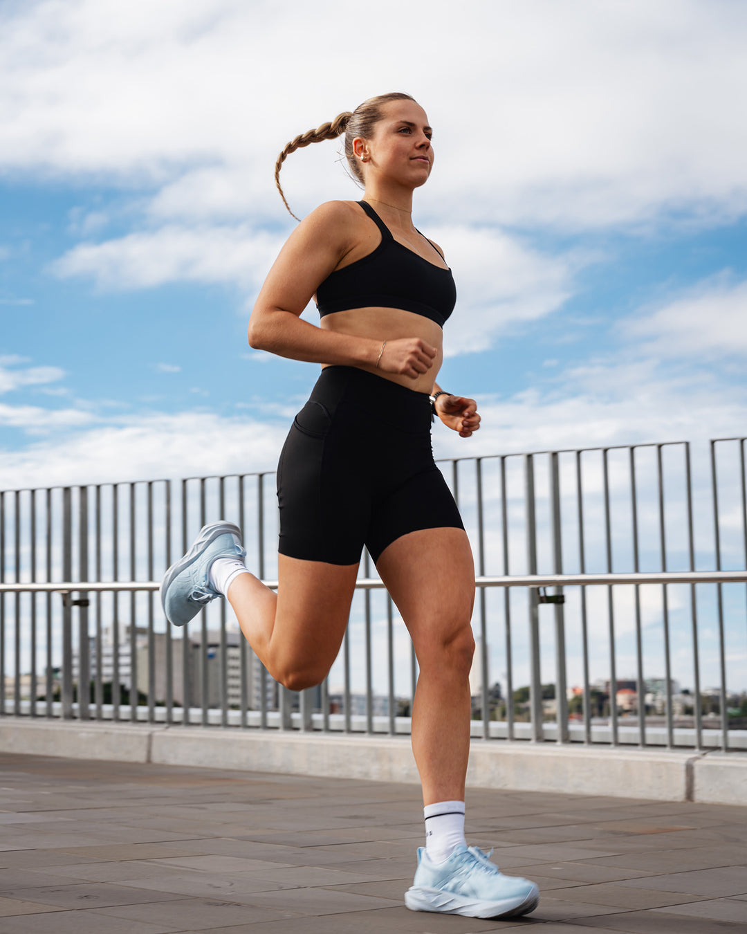 Woman wearing Elite Run High-Rise 7&quot; Short Pockets - Black | Model:Ali | Size:S