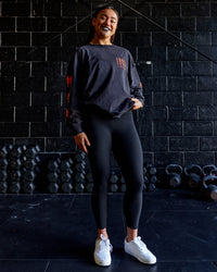 Woman wearing Inferno Journey FLXCotton Oversized Long Sleeve Tee - Washed Black-Ultra Orange | Model:Teraipine | Size:M