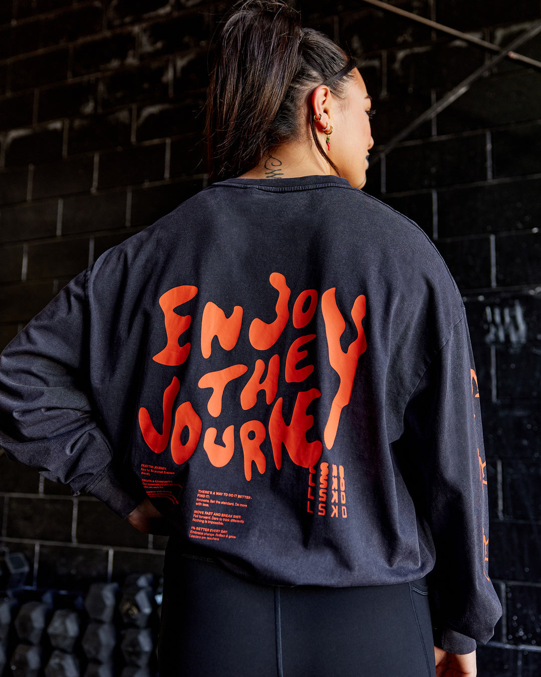 Woman wearing Inferno Journey FLXCotton Oversized Long Sleeve Tee - Washed Black-Ultra Orange | Model:Teraipine | Size:M