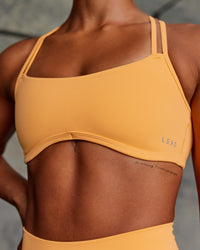 Woman wearing Interstellar Sports Bra - Warm Apricot | Model:Janet | Size:S