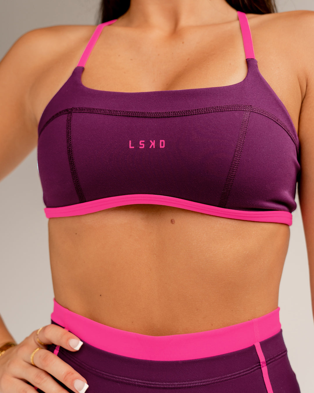 Woman wearing Liberate Sports Bra - Plum Caspia-Ultra Pink | Model:Jordi | Size:S