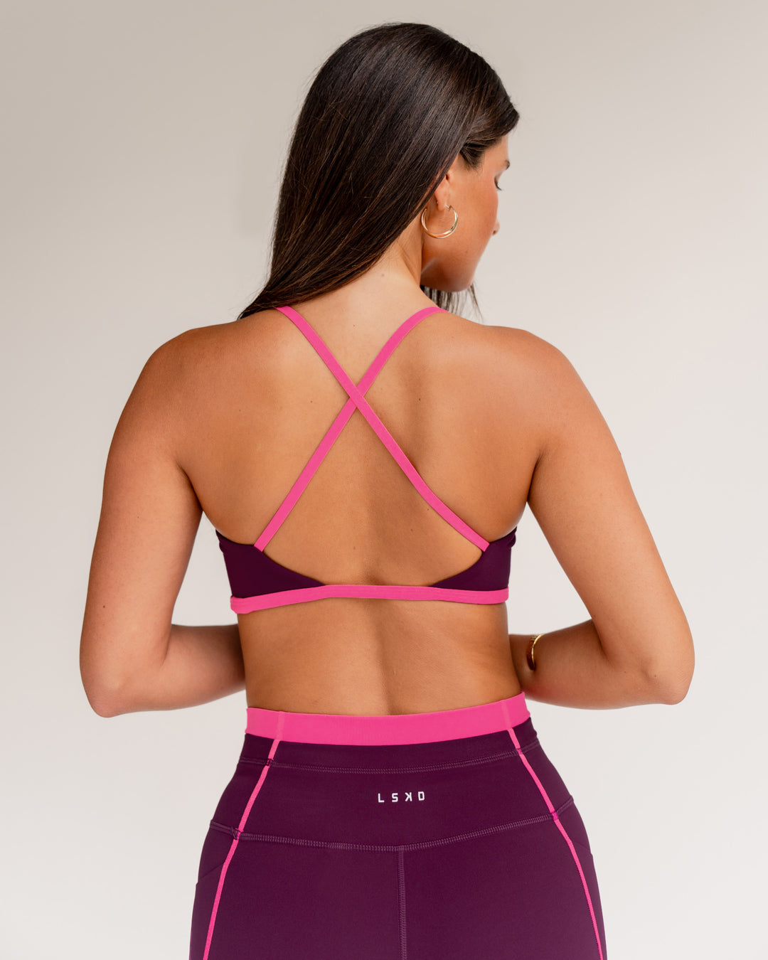 Woman wearing Liberate Sports Bra - Plum Caspia-Ultra Pink | Model:Jordi | Size:S