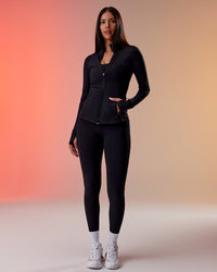 Woman wearing Stride Thermal Zip Through Jacket - Black | Model:Rhiley | Size:S