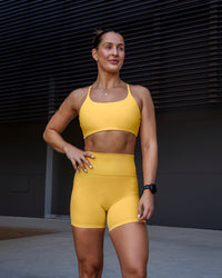 Woman wearing Twist Sports Bra in Banana Cream | Size:S