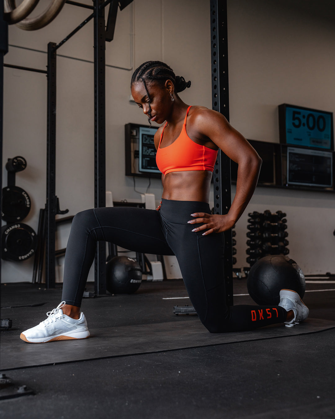 Woman wearing Twist Sports Bra - Ultra Orange | Model:Cebile | Size:S