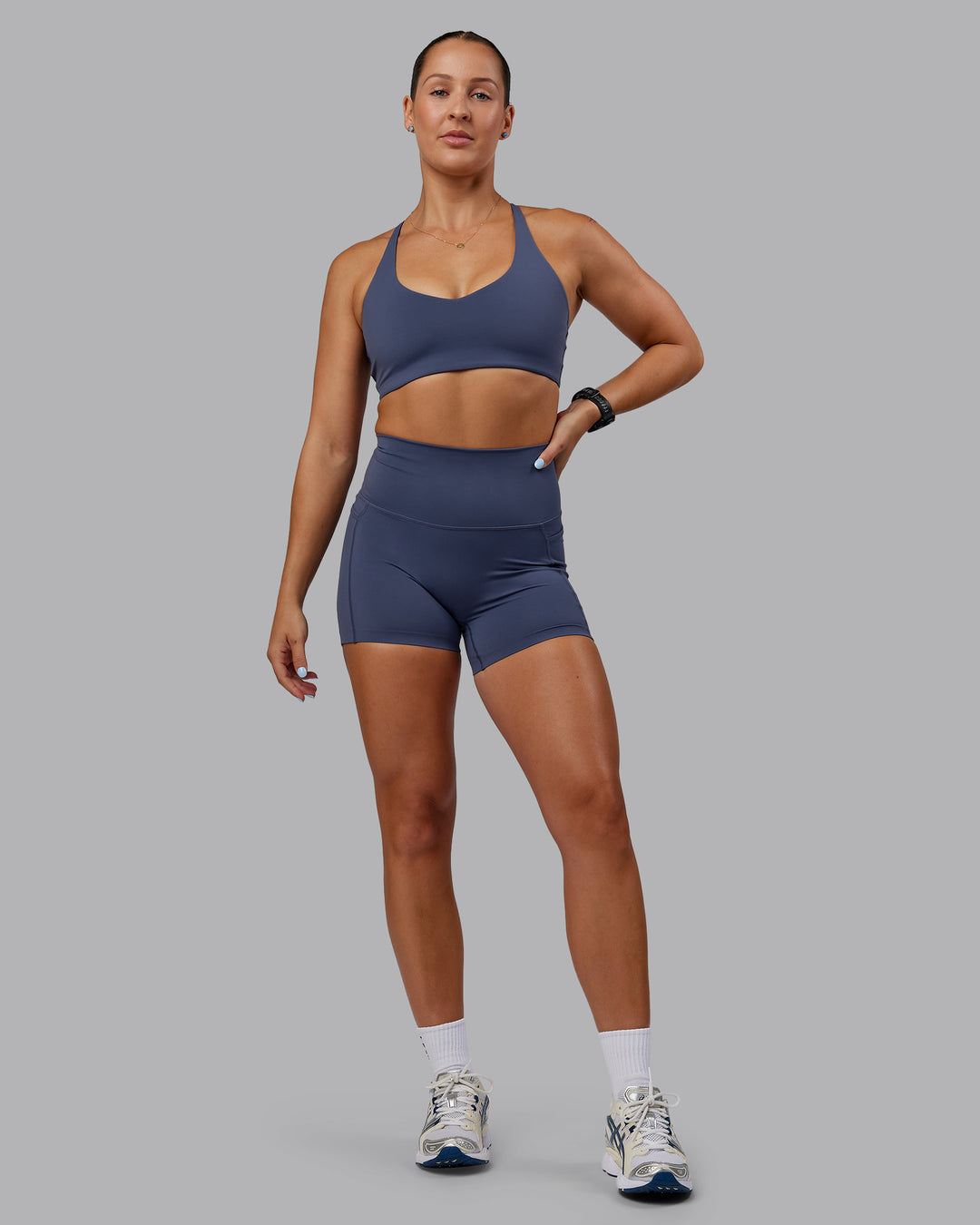 Woman wearing Abs Elixir Ultra High-Rise 4&quot; Short Pockets - Nightshadow Blue