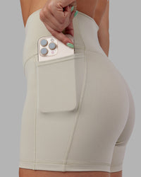Woman wearing Abs Fusion High-Rise 4" Short Pockets - Shale Beige | Model:Abbey | Size:S