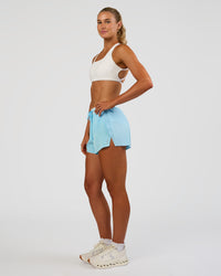 Woman wearing Accelerate 3" High-Rise Running Short - Baltic Sea-Off White | Model:Emelia | Size:S