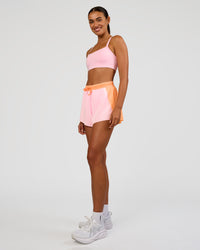 Woman wearing Accelerate 3" High-Rise Running Short - Cantaloupe-Marshmallow | Model:Ruby | Size:S