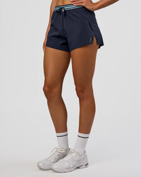 Woman wearing Accelerate 3" High-Rise Running Short - Future Navy-Baltic Sea | Set:true | Angle:side | Model:Evie | Size:S
