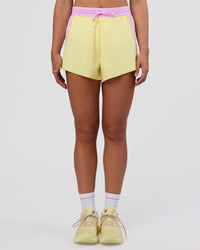 Woman wearing Accelerate 3" High-Rise Running Short - Marshmallow-Lemon | Set:true | Angle:front | Model:Grace | Size:S