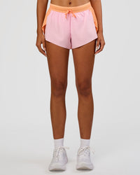 Woman wearing Accelerate 3" Mid-Rise Running Short - Cantaloupe-Marshmallow | Set:true | Angle:front | Model:Ruby | Size:S