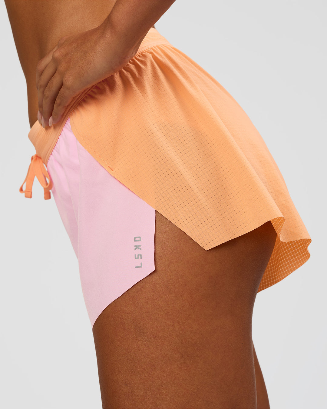 Woman wearing Accelerate 3" Mid-Rise Running Short - Cantaloupe-Marshmallow | Model:Ruby | Size:S