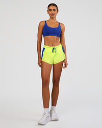 Woman wearing Accelerate 3" Mid-Rise Running Short - Electric Indigo-Lime Glo | Model:Ruby | Size:S