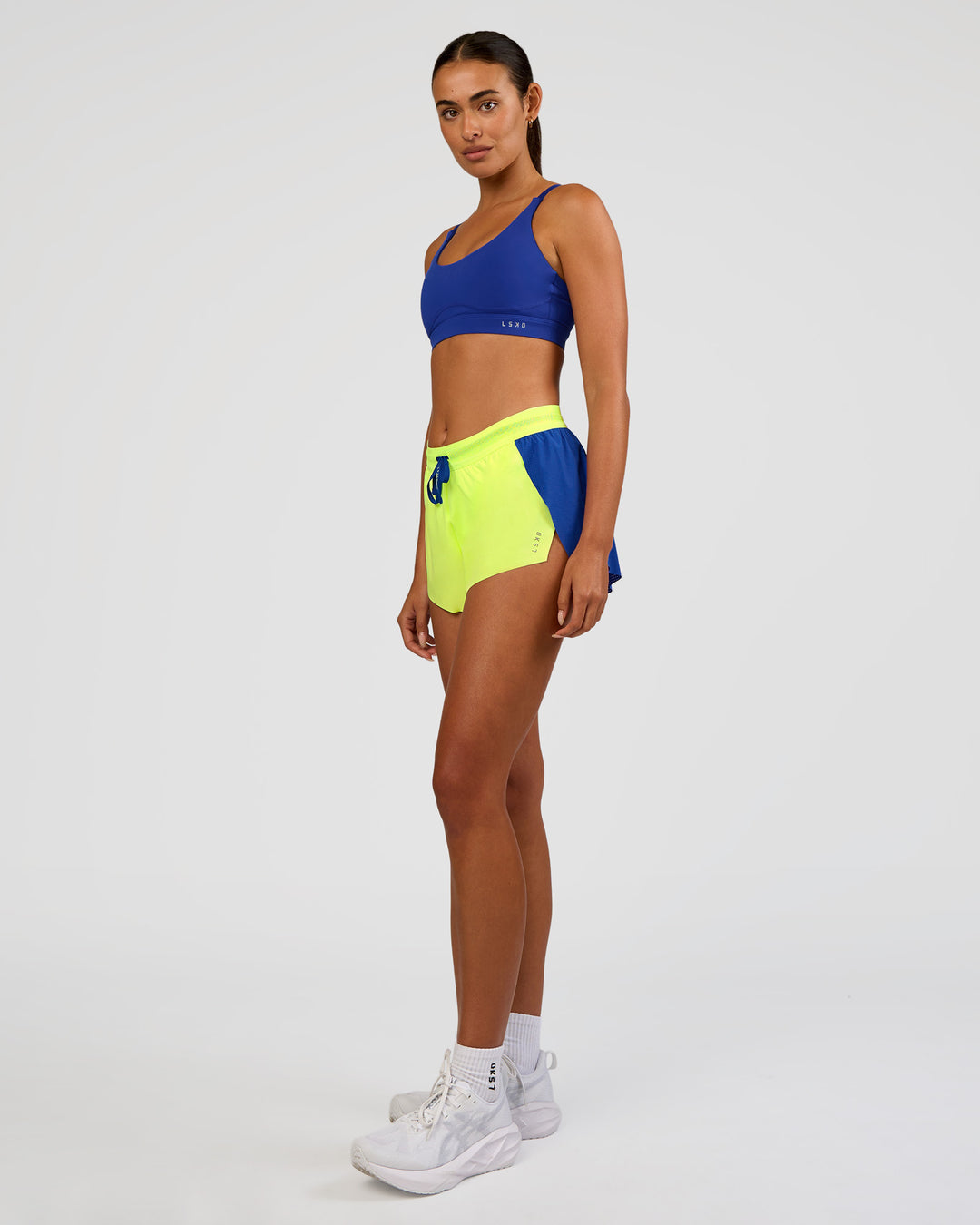 Woman wearing Accelerate 3" Mid-Rise Running Short - Electric Indigo-Lime Glo | Model:Ruby | Size:S