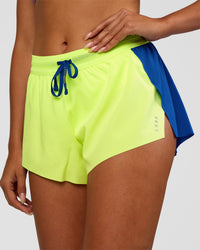 Woman wearing Accelerate 3" Mid-Rise Running Short - Electric Indigo-Lime Glo | Set:true | Angle:closeup | Model:Ruby | Size:S