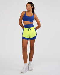 Woman wearing Accelerate 3" Mid-Rise Running Short - Electric Indigo-Lime Glo | Model:Ruby | Size:S