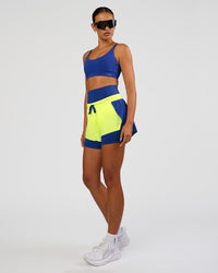 Woman wearing Accelerate 3" Mid-Rise Running Short - Electric Indigo-Lime Glo | Model:Ruby | Size:S