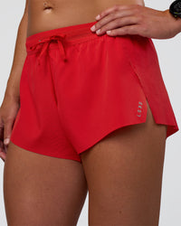 Woman wearing Accelerate 3" Mid-Rise Running Short - Flame | Set:true | Angle:closeup | Model:Sav | Size:S