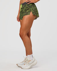 Woman wearing Accelerate 3" Mid-Rise Running Short - Friction Print Hyper Green | Set:true | Angle:side | Model:Emelia | Size:S