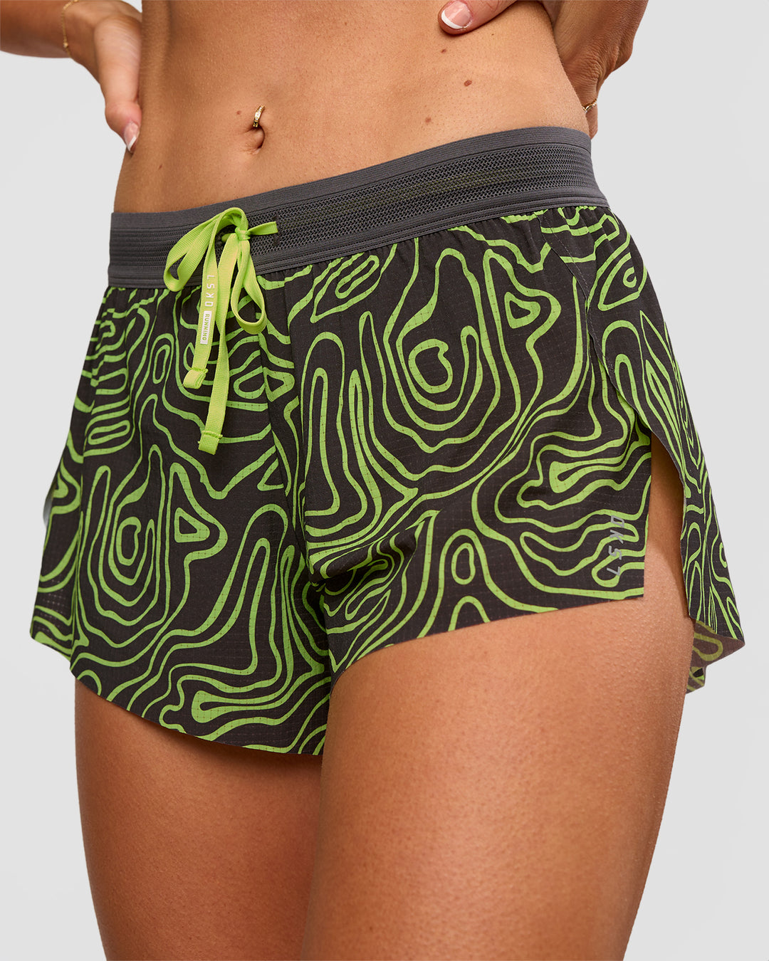 Woman wearing Accelerate 3" Mid-Rise Running Short - Friction Print Hyper Green | Set:true | Angle:closeup | Model:Emelia | Size:S