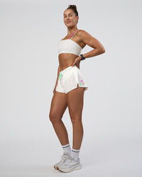 Woman wearing Accelerate 3" Mid-Rise Running Short - Off White-Floral Sticker | Model:Abbey | Size:S