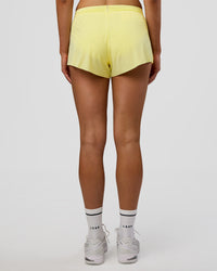 Woman wearing Accelerate 3" Mid-Rise Running Short - Yellow Fizz | Set:true | Angle:back | Model:Evie | Size:S