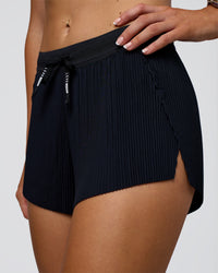 Woman wearing Accelerate 3" Pleated Mid-Rise Running Short - Black | Model:Emelia | Size:S
