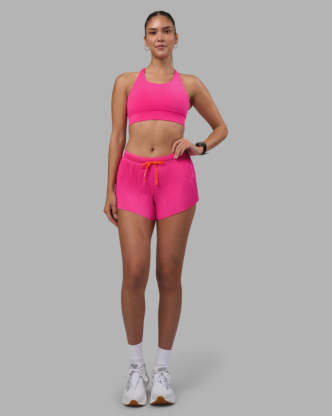 Woman wearing Accelerate 3&quot; Pleated Running Short - Ultra Pink | Model:Rhiley | Size:S