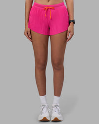 Woman wearing Accelerate 3" Pleated Running Short - Ultra Pink | Model:Rhiley | Size:S